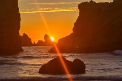 Sunset-beach-close-sun-sliding-past-rock